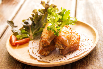 chicken wings with vegetables on wooden table