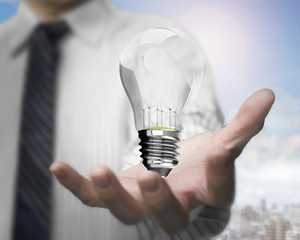 Businessman hand holding lightbulb with wind turbines inside