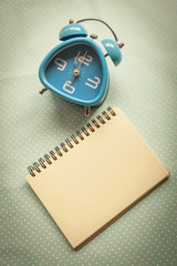 Vintage tone style blue clock with blank notebook