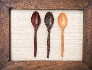 Wooden spoon on canvase background in wooden frame vintage style