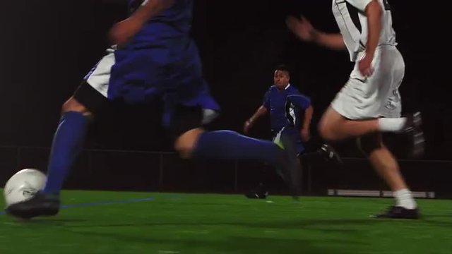 The camera pans with a soccer team as they score a goal

