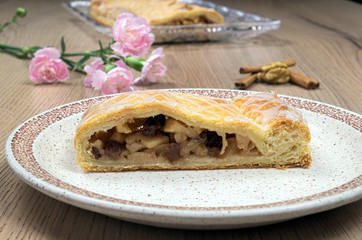 Homemade strudel with walnuts and carnations on a plate