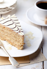 Traditional Hungarian Esterhazy cake with coffee cup and vintage postcards .