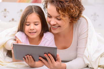 Happy mother and daughter surfing the Internet