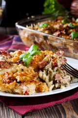 Portion of fusilli pasta casseroles, sausages and zucchini
