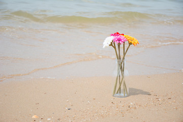 Fototapeta na wymiar Artificial flowers on the beautiful beach