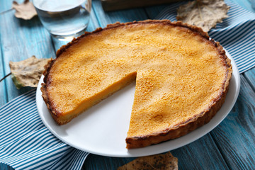 Tasty pumpkin pie on plate on a blue wooden table