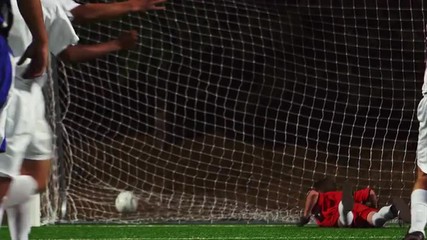 A soccer player making a penalty kick into the goal and celebrating
