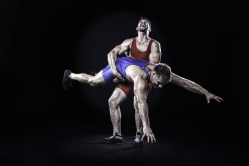 Fototapeta na wymiar Freestyle wrestler throwing action isolated on black background