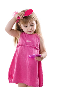 little girl in a pink dress posing for the camera showing funny faces