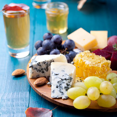 Cheese plate with fresh grape, honey, nuts,plum jelly, marmalade