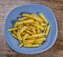 French fries  on the plate on wooden background