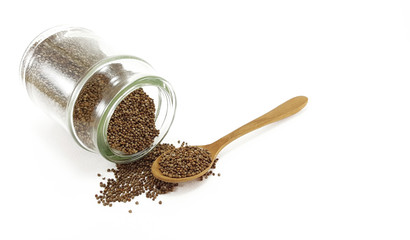 Perila seed in glass jar with wooden spoon; white background