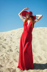 Fototapeta premium Beautiful Woman in Red Dress on the Beach