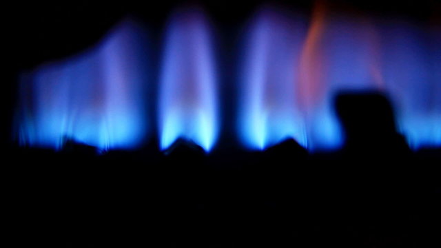 Blue flames of a gas burner inside of a boiler