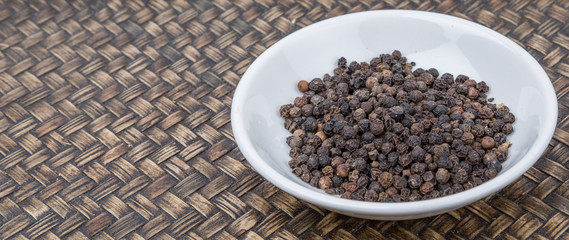 Black peppercorn over wicker background