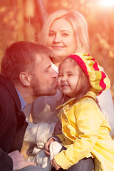 Happy European Family of Three People Father Mother Little Baby Girl Dad Tenderly Kissing Child