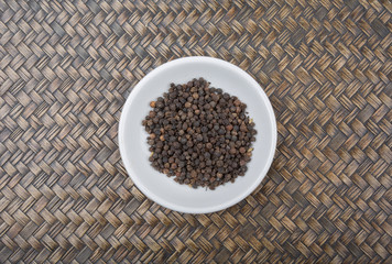 Black peppercorn over wicker background