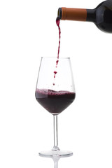 red wine poured into the glass on white