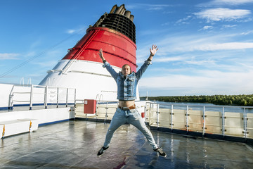 The man in the jump poses on the upper deck of the ferry