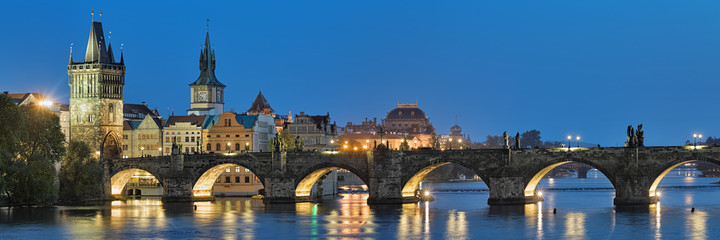 Evening panorama of the Charles Bridge in Prague, Czech Republic, with Old Town Bridge Tower, Old Town Water Tower and dome of the National Theatre