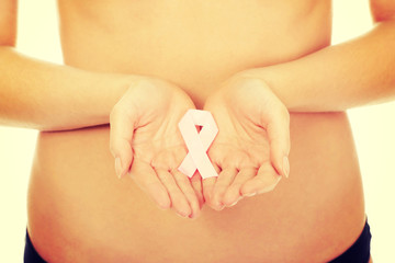 Female hands holding pink ribbon.