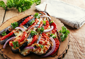baked eggplant with cheese and tomatoes on a wooden surface