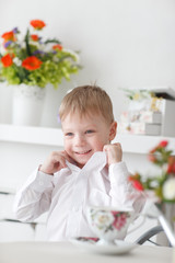 Beautiful happy blond boy holding a carrot