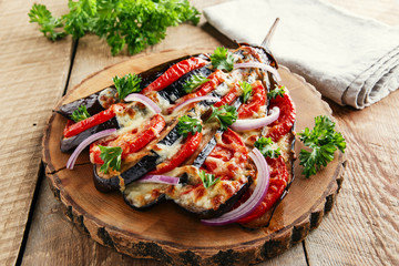 baked eggplant with cheese and tomatoes on a wooden surface