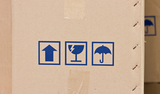 Safety, fragile icons on a cardboard parcel.