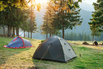 Tents in camping in the mountains surrounded with forest