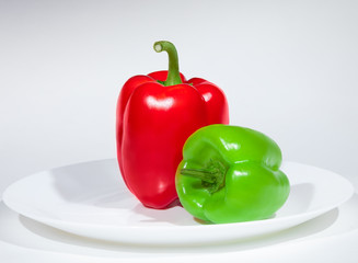 two delicious tasty fresh glistening peppers. Red and green