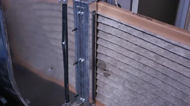 Replacing a dirty air filter in a household furnace unit.	 	