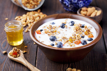 Healthy breakfast. Fresh granola, muesli with berries, honey and milk 