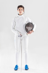 Portrait of woman wearing white fencing costume practicing with the sword