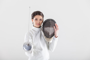 Portrait of woman wearing white fencing costume practicing with the sword
