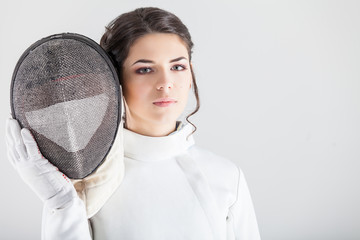 Portrait of woman wearing white fencing costume practicing with the sword