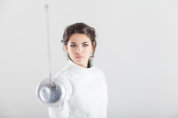 Portrait of woman wearing white fencing costume practicing with the sword