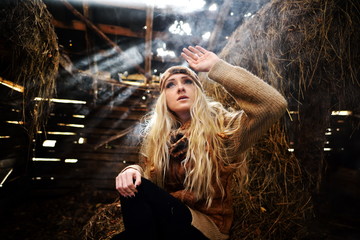 Beautiful woman relaxing in straw in autumn