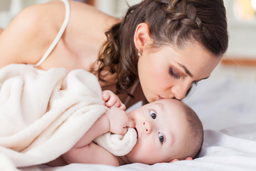 Happy family laughing faces, mother holding adorable child baby boy, smiling and hugging