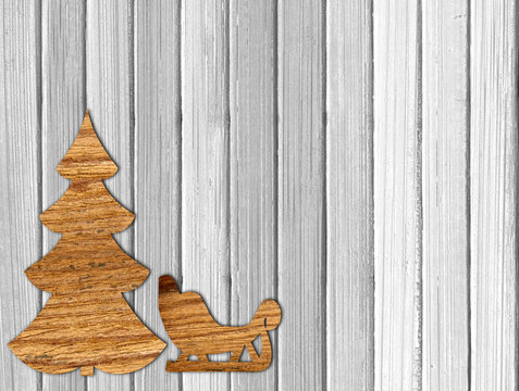 Plywood Christmas tree and sleigh on white wooden background