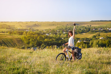 Fototapeta premium Travel with bicycle alone - young woman on the field