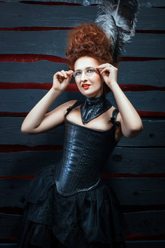 Old-fashioned girl in a corset and high hairdo.