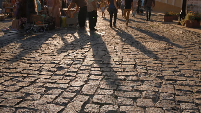 Long shadow of walking in sunset light people