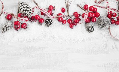 Obraz na płótnie Canvas Christmas Decoration Ribbon Frame with Red Berries and Pine Cone