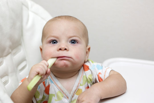 Pensive Baby Boy Eating Celery
