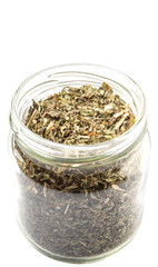 Dried lemon balm leaves in a mason jar over white background