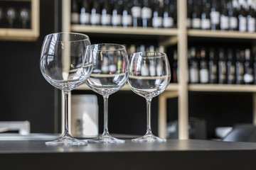 Glasses of wine on counter and bar on background
