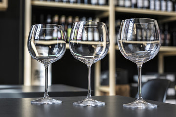 Glasses of wine on counter and bar on background