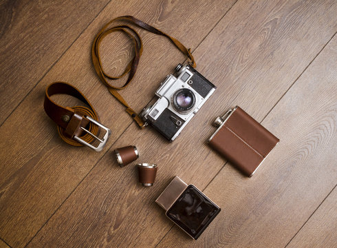 Vintage camera and leather belt on wooden floor
